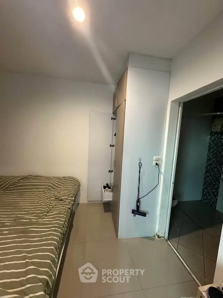 Cozy bedroom with modern design and tiled flooring, featuring a compact layout.