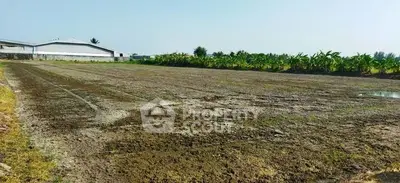 Expansive agricultural land with potential for development, surrounded by lush greenery and clear skies.