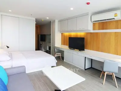 Modern studio apartment with sleek design, featuring a cozy bed, stylish furniture, and efficient use of space.