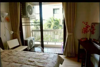 Cozy bedroom with balcony view, air conditioning, and elegant decor in a modern apartment.