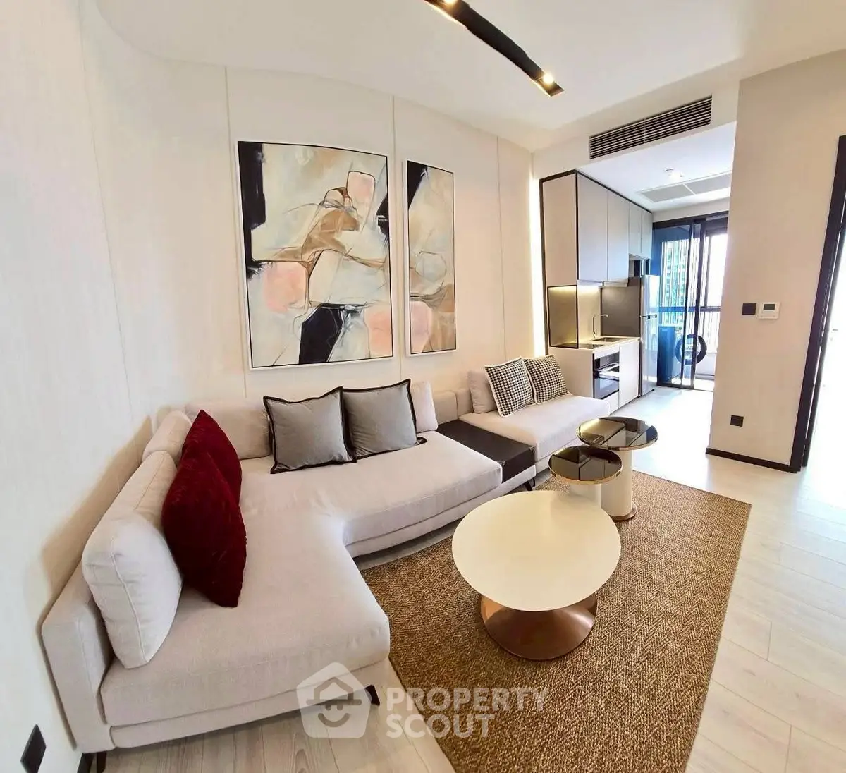 Modern living room with stylish decor and open layout, featuring a cozy sectional sofa and contemporary artwork.