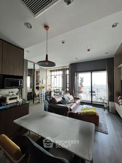 Modern living room with open layout and city view, featuring stylish furniture and decor.