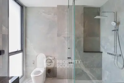 Modern bathroom with sleek shower and large window for natural light.
