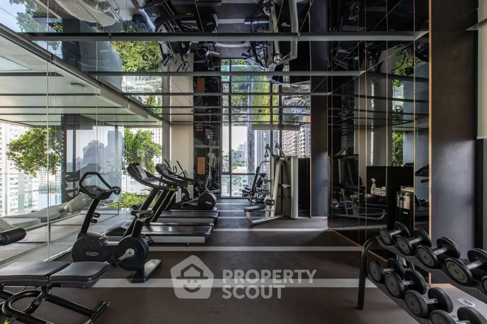 Luxurious gym with modern equipment and mirrored walls in a high-end residential building.