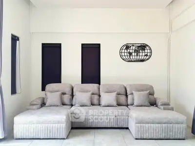 Spacious modern living room with elegant gray sectional sofa and minimalist decor.