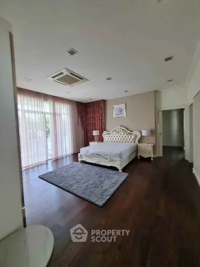 Luxurious bedroom with elegant decor and large windows offering natural light