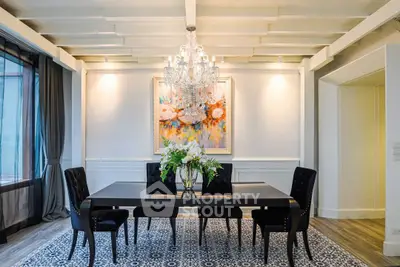Elegant dining room with chandelier, modern decor, and stylish furniture in a luxurious home setting.