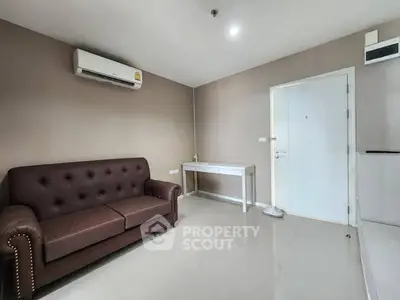 Modern living room with brown sofa and air conditioning in a sleek apartment.
