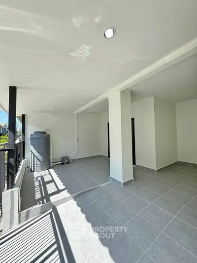 Spacious balcony with modern tiles and ample natural light, perfect for relaxation.