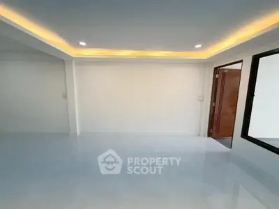 Spacious modern living room with recessed lighting and sleek flooring