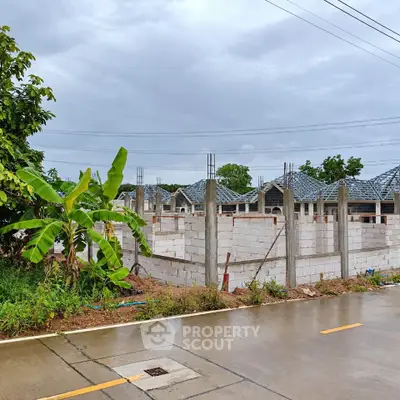 Newly constructed residential building with unfinished walls and roof under a cloudy sky.