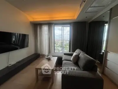 Modern living room with large window and cozy sofa, offering a bright and inviting atmosphere.