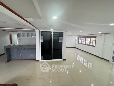 Spacious open-plan living area with modern kitchen and large windows