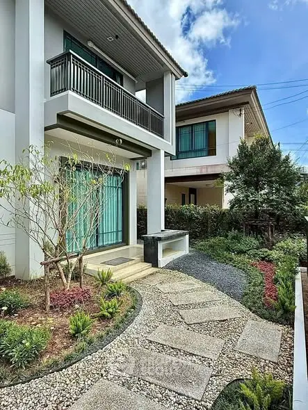 Modern two-story house with landscaped garden and stone pathway