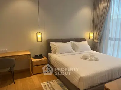 Elegant bedroom with modern decor and cozy lighting, featuring a comfortable bed and stylish furnishings.