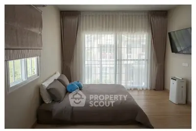 Spacious bedroom with large window and modern decor