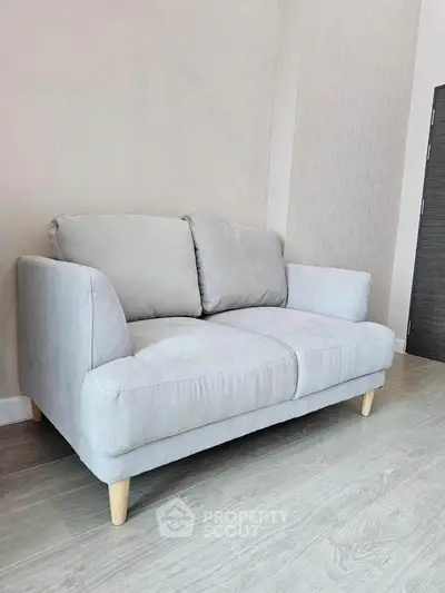 Modern gray sofa in a stylish living room with wooden flooring.