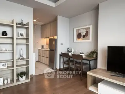Modern living room with open kitchen, stylish decor, and wooden flooring in a cozy apartment.