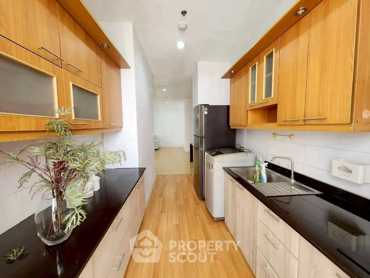 Modern kitchen with sleek black countertops and wooden cabinets
