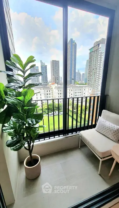 Chic urban balcony with stunning cityscape view and cozy seating area.