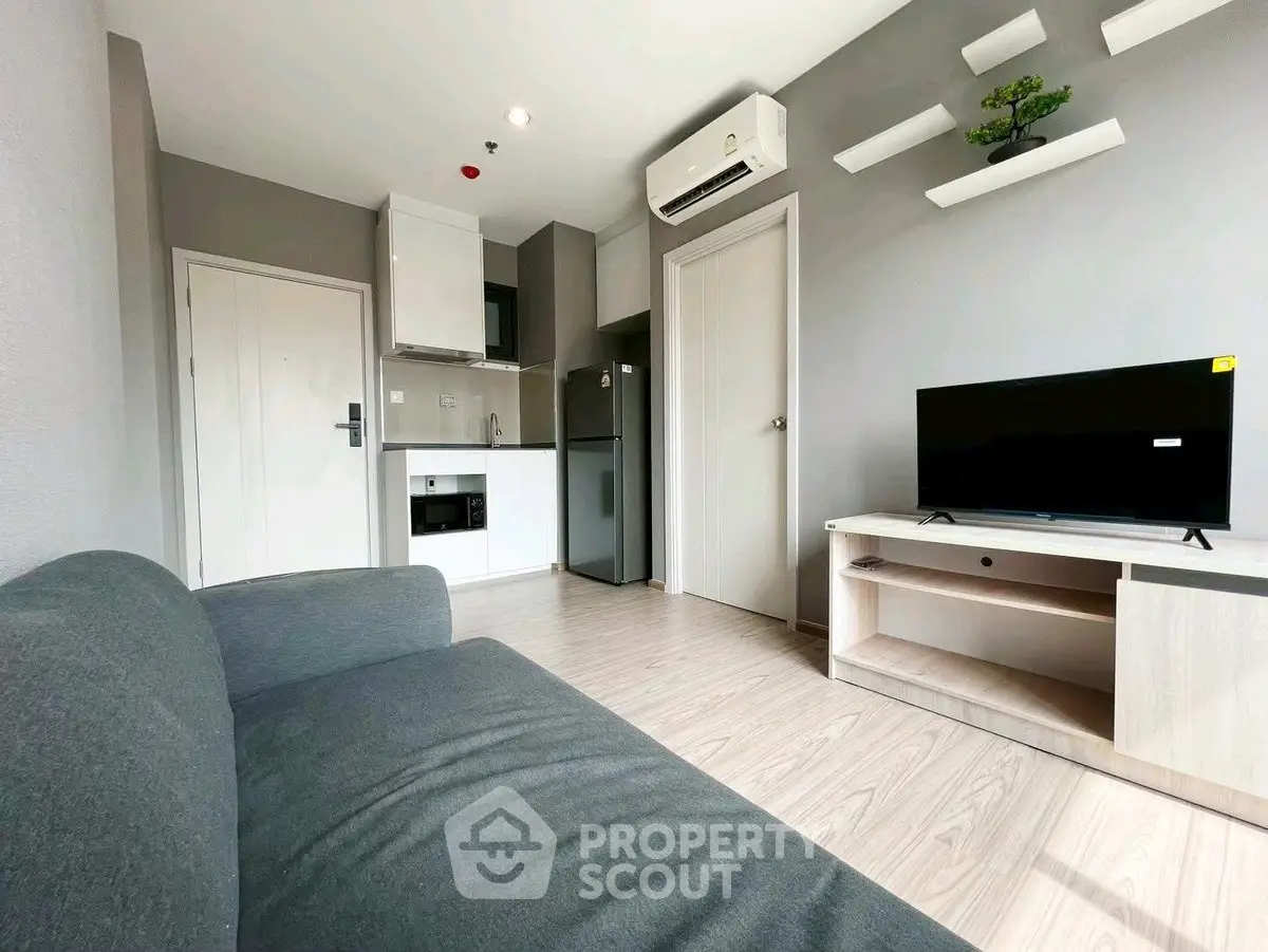 Modern living room with sleek furniture and compact kitchen area