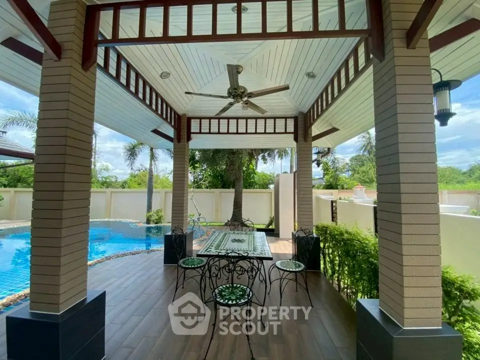 Luxurious outdoor patio with elegant dining set and pool view, perfect for relaxation and entertaining.