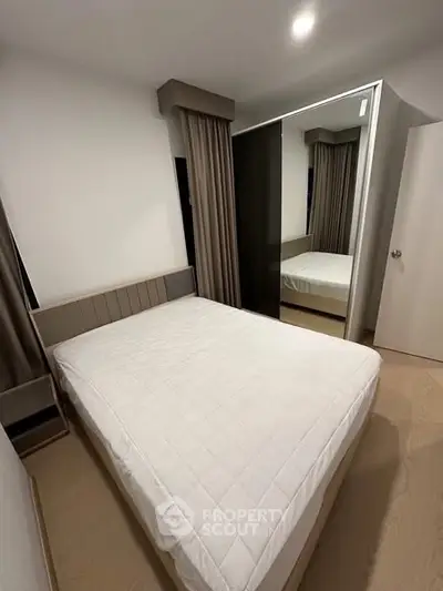 Modern bedroom with minimalist design and large mirror wardrobe