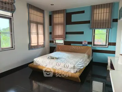 Spacious bedroom with modern design and large windows for natural light.