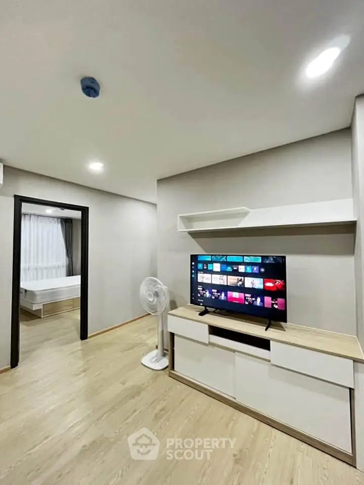 Modern living room with sleek TV setup and wooden flooring