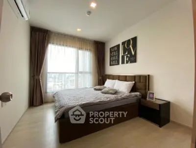 Modern bedroom with large window and stylish decor in a cozy apartment.