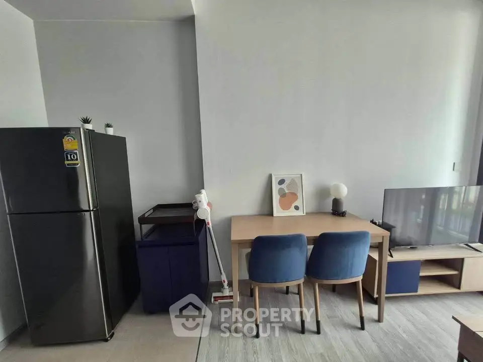 Modern living room with sleek furniture and appliances, featuring a fridge and stylish decor.
