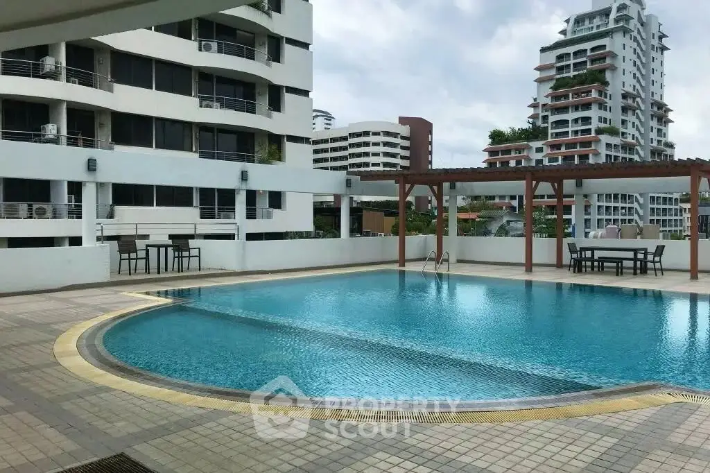 Luxurious condominium pool area with modern architecture and city views.
