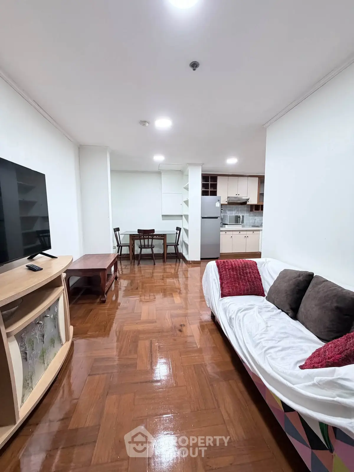 Spacious living room with modern furniture and open kitchen layout in a stylish apartment.