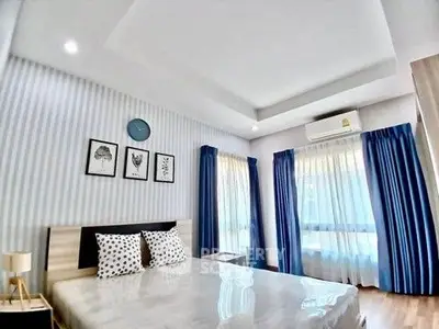 Bright and airy bedroom with modern decor and large windows.