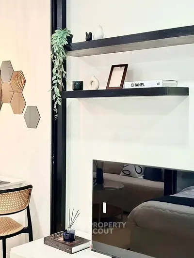 Modern living room with stylish shelves and decor, featuring a sleek TV setup and contemporary furniture.