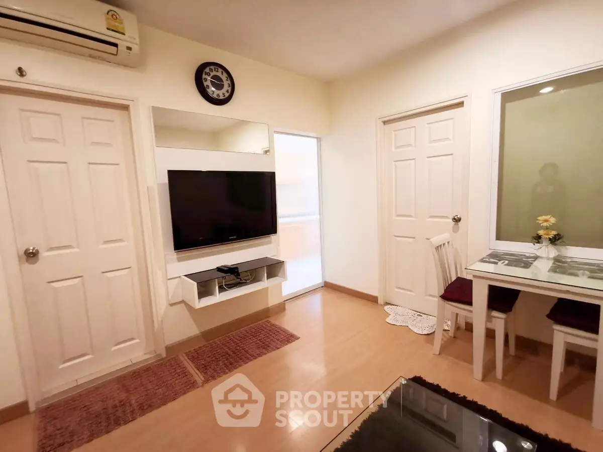 Cozy living room with modern decor and wall-mounted TV in a stylish apartment.