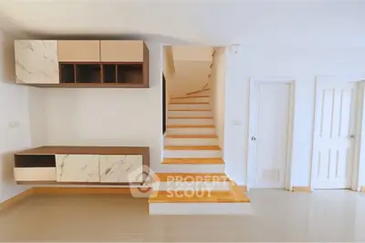 Modern interior with stylish staircase and storage cabinets in a bright living space.