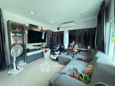 Spacious living room with modern decor and large TV, perfect for family gatherings.