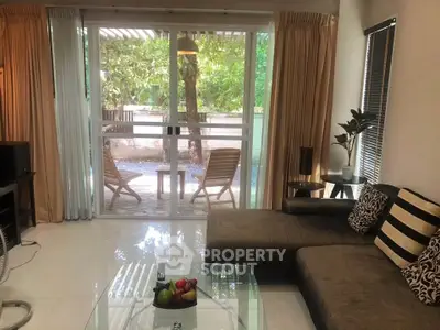 Charming living room with garden view and cozy seating area, perfect for relaxation.