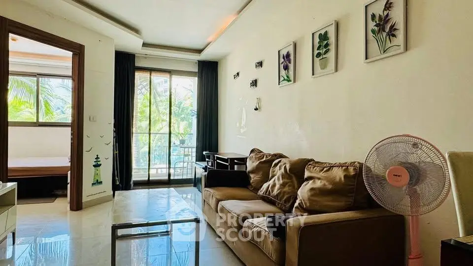 Spacious living room with modern decor and balcony view, perfect for relaxation.