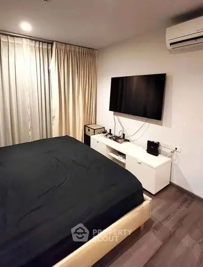 Modern bedroom with sleek design, featuring a wall-mounted TV and air conditioning for ultimate comfort.