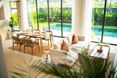 Luxurious living room with pool view, elegant dining setup, and modern decor in a serene setting.