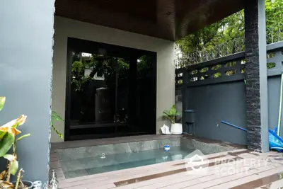 Modern outdoor plunge pool with wooden deck and privacy wall