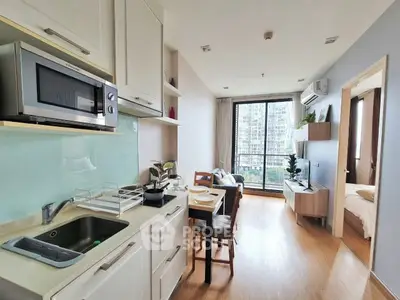 Modern open-layout kitchen and living room with balcony view in a stylish apartment.