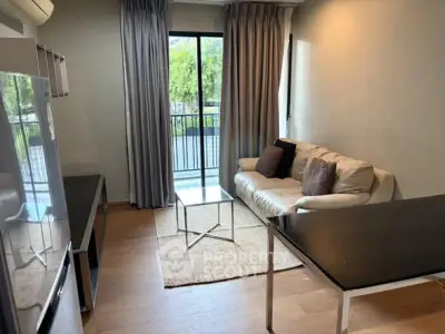 Modern living room with balcony view, featuring sleek furniture and natural light.