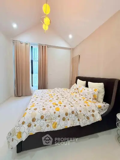 Spacious bedroom with modern decor and natural light, featuring a stylish bed and elegant lighting.