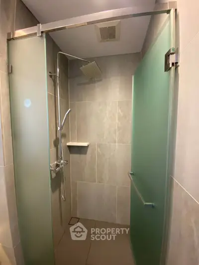 Modern bathroom with frosted glass shower doors and sleek fixtures.