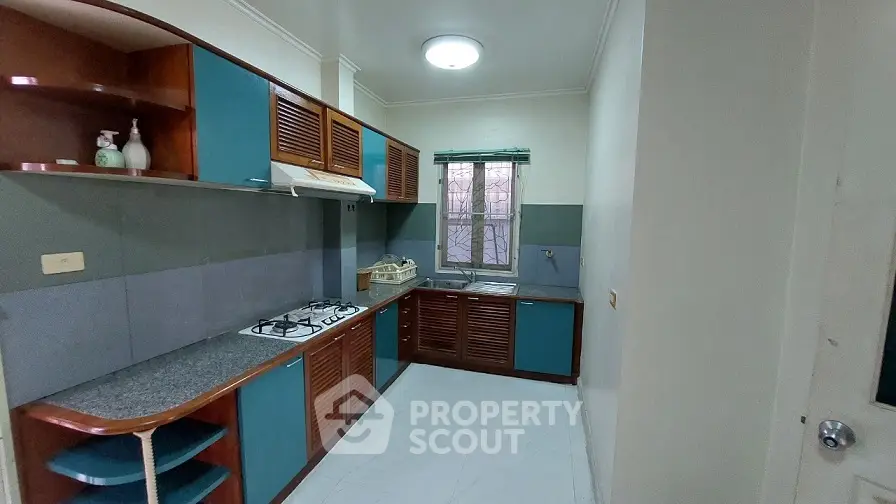 Spacious kitchen with modern gas stove and ample storage in a cozy apartment.