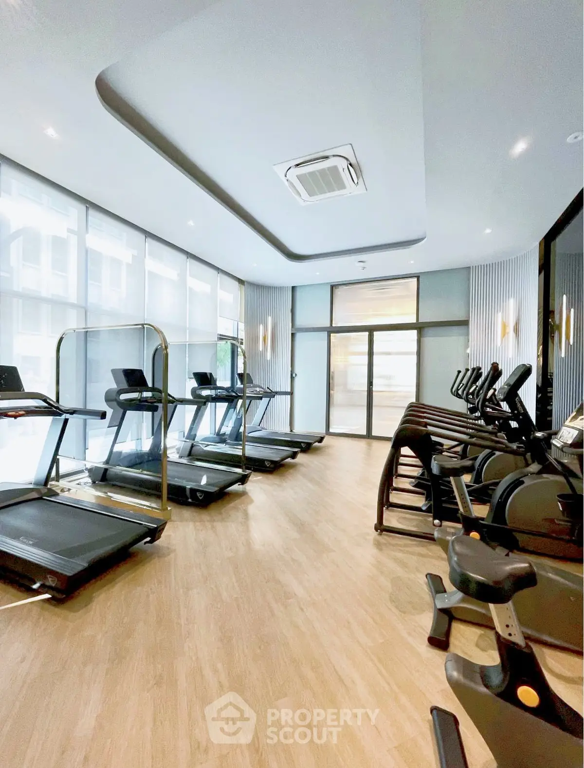 Modern gym with state-of-the-art equipment and sleek design in luxury building.