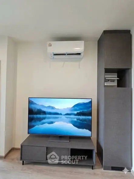 Modern living room with sleek TV setup and air conditioning unit, perfect for comfortable living.